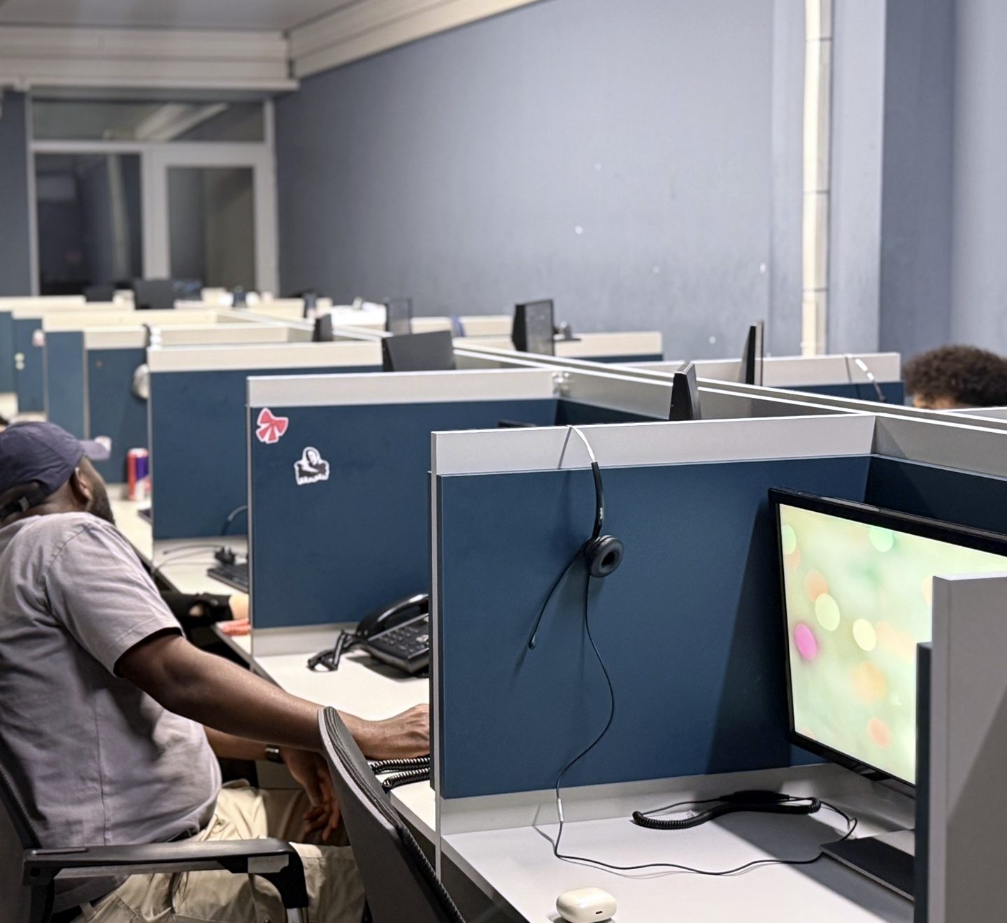 DSPro agent in a cap at his desk on the call floor