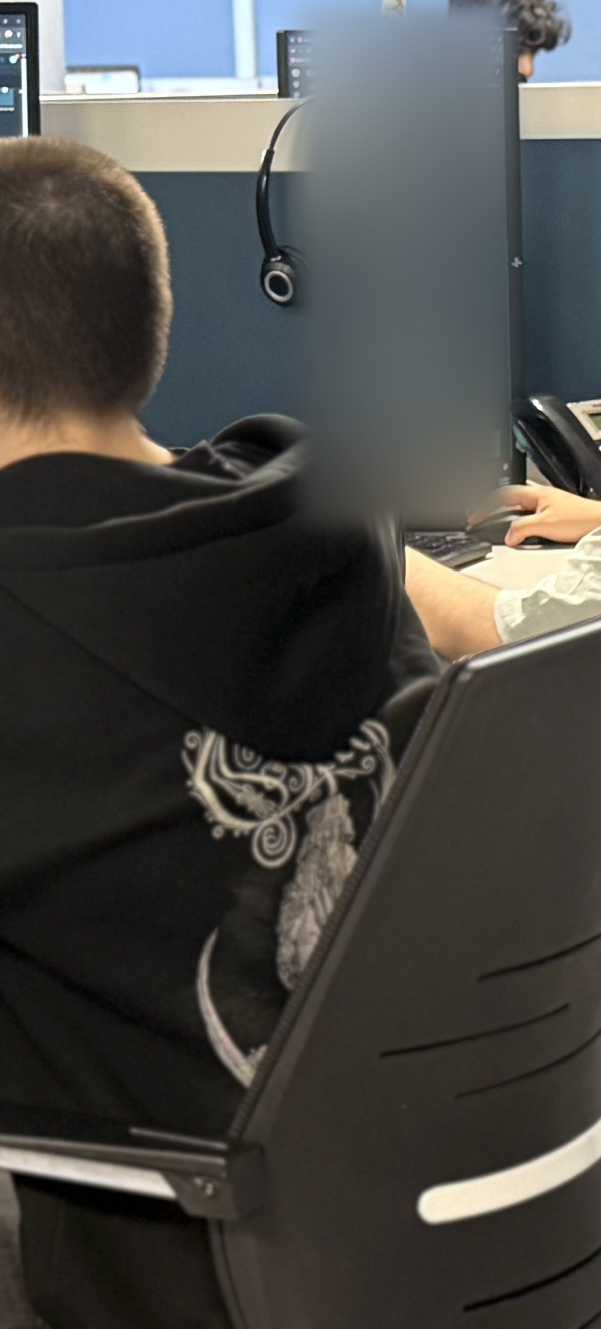 DSPro agent at his desk, a spare headset hanging on the partition