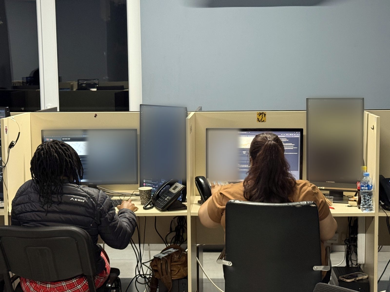 Two DSPro agents at neighbouring desks, seen from behind